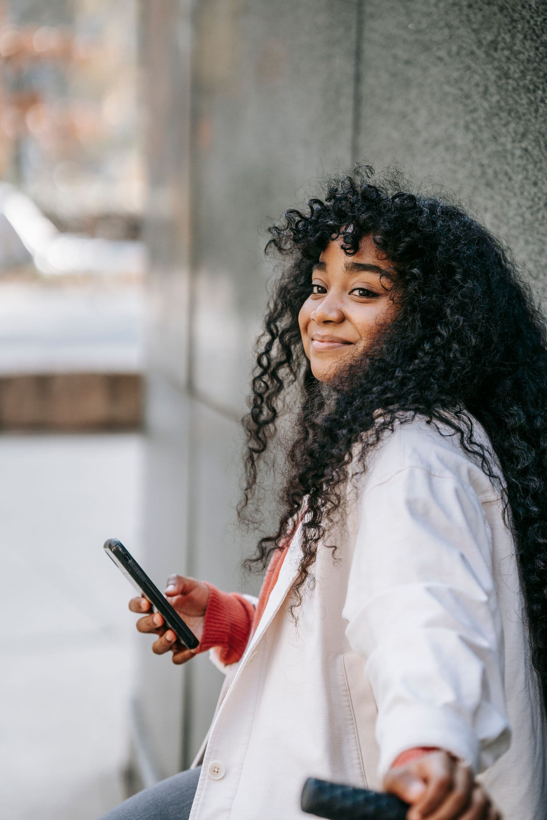 A woman walking through the city, phone in hand